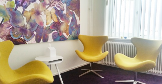 Individuele gespreksruimte geel met drie fauteuils